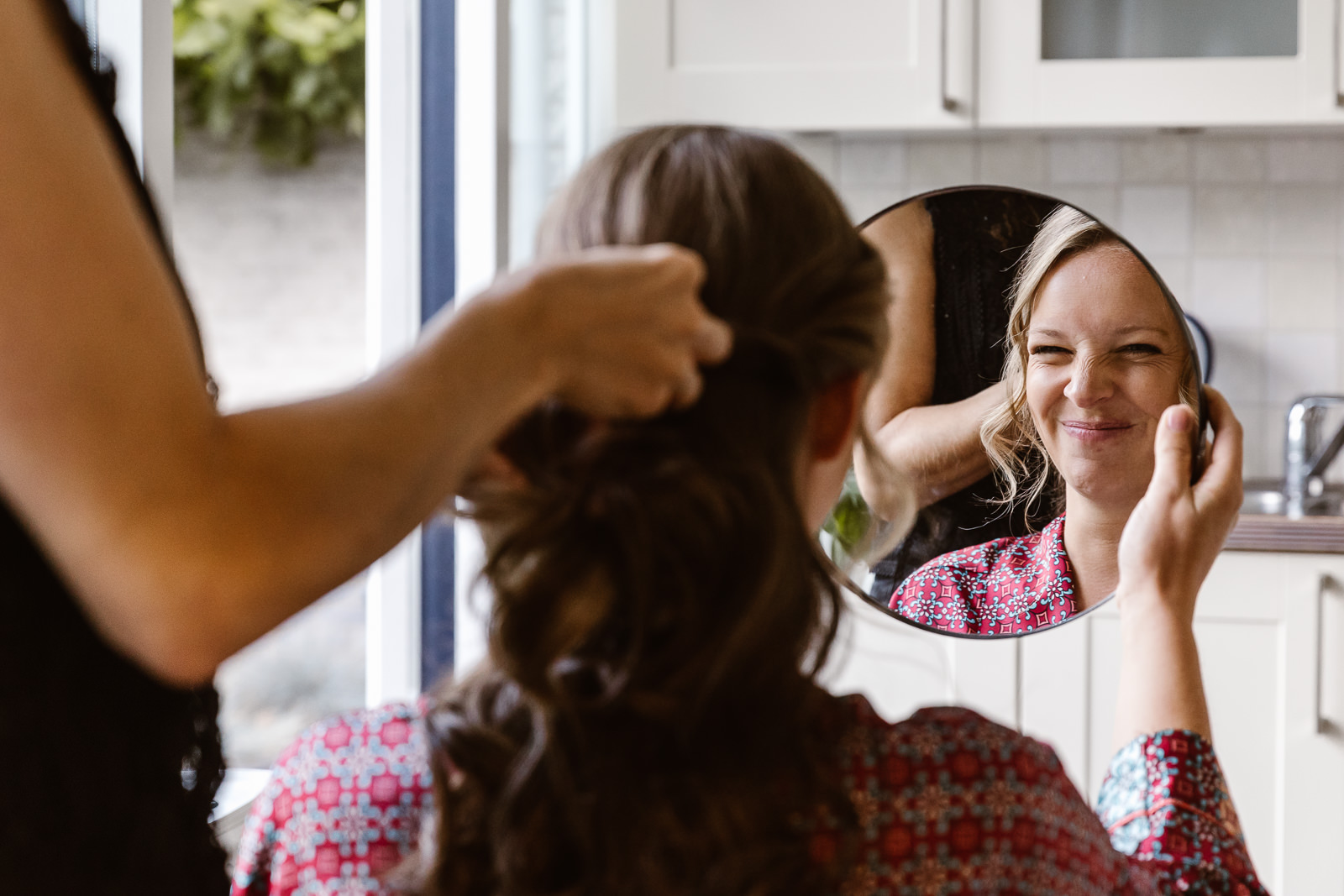 Bruid kijkt in spiegel tijdens make up