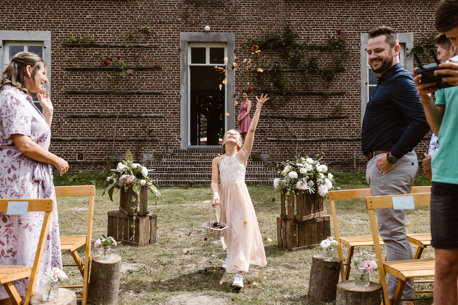 Bloemenmeisje strooit blaadjes bij ceremonie